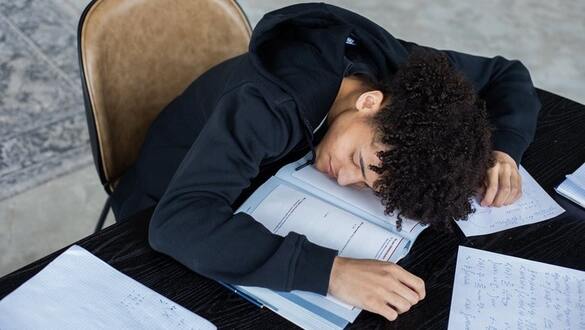 college student sleeping on homework